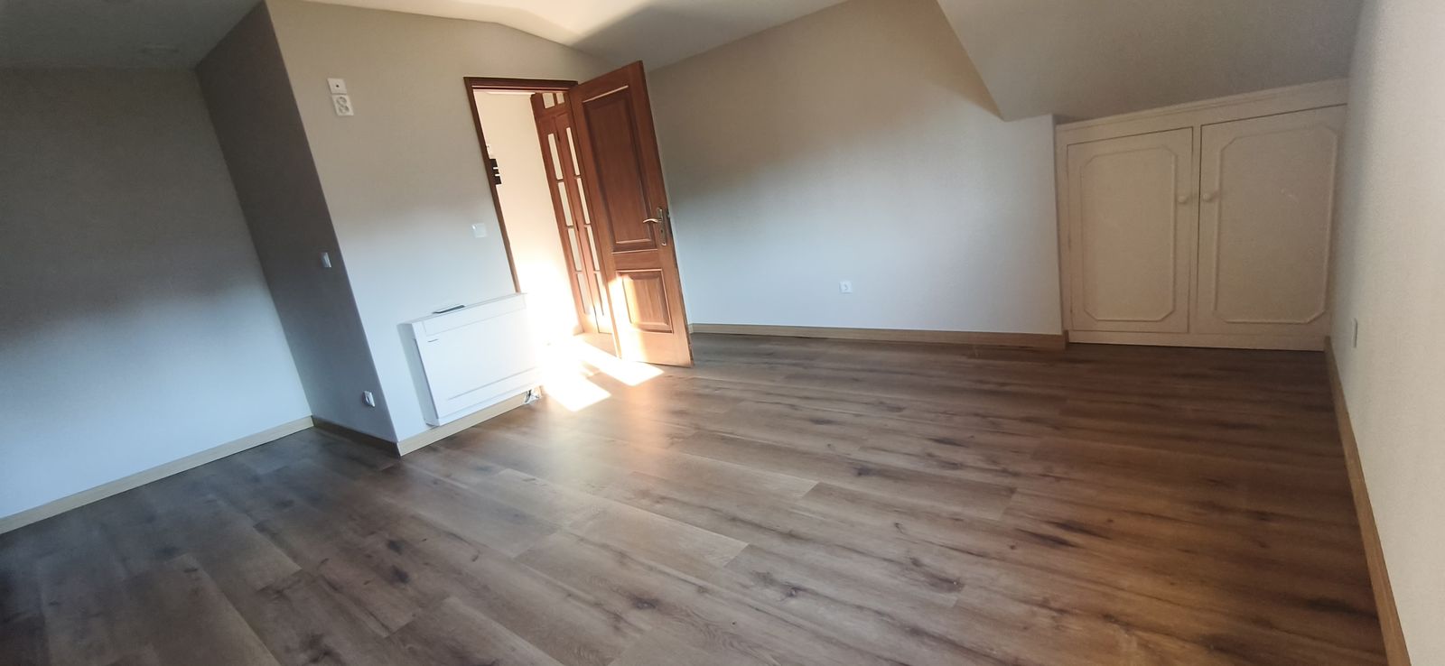 Habitación amplia con armario empotrado bajo la buhardilla